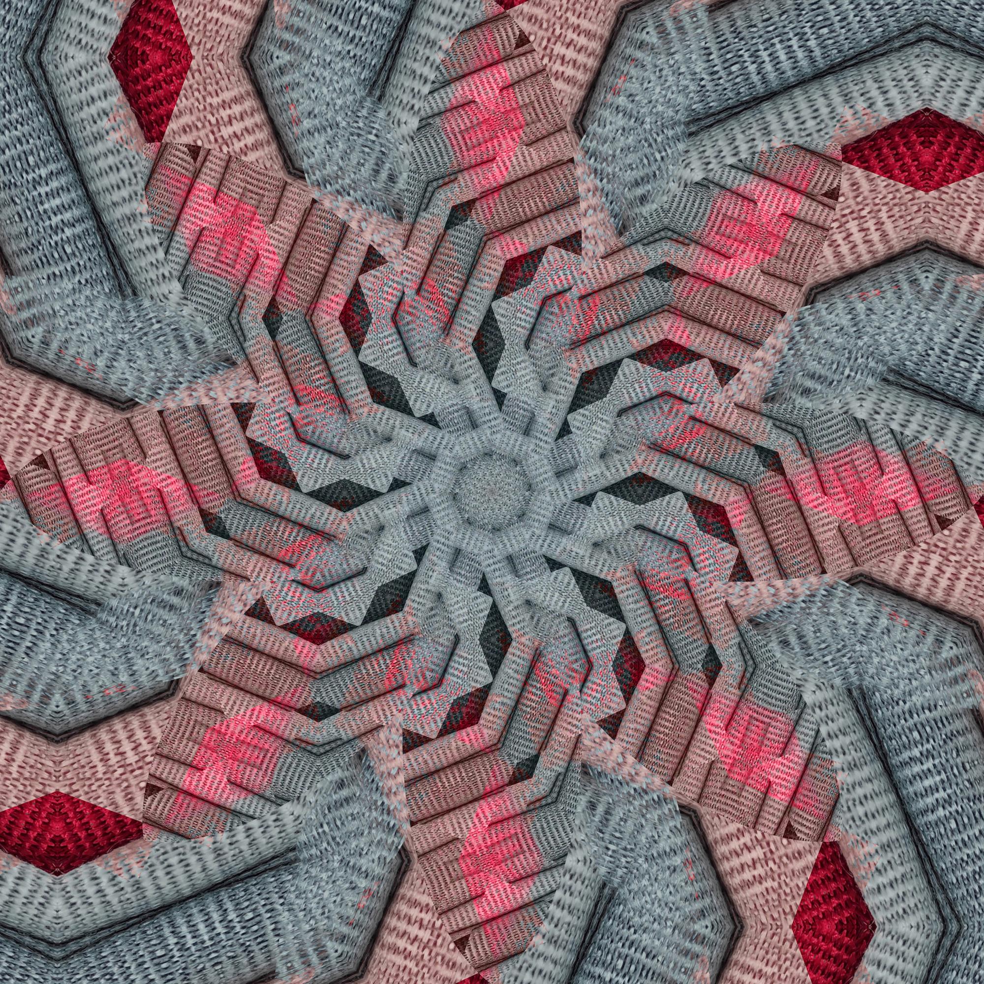 Mano che ricama un motivo geometrico su tessuto tecnico